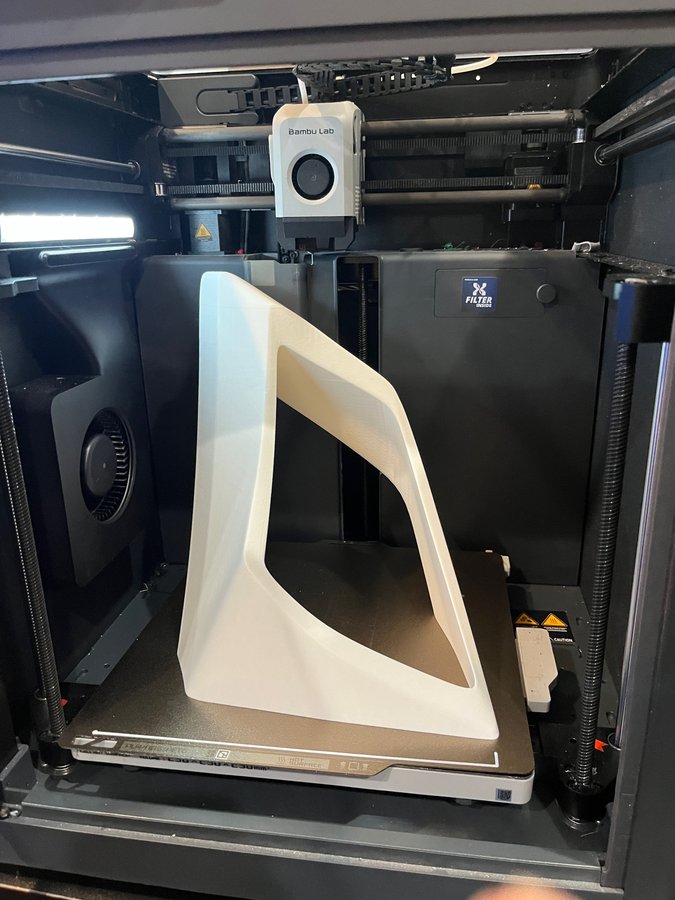 Large white 3D printed bracket on the printer build plate
